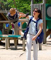 Mom using her BackTpack with her kids on the playground
